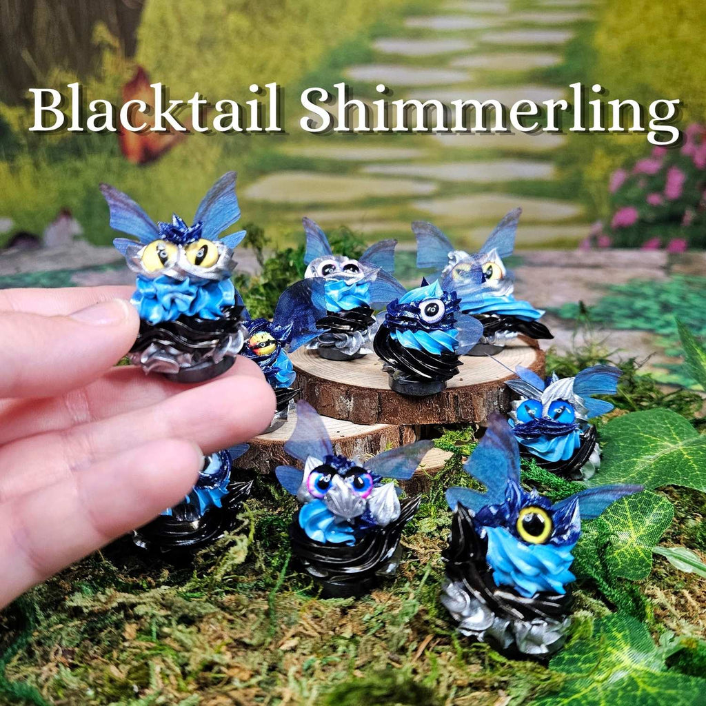 group of blue, black, silver frosting creatures sitting in grass