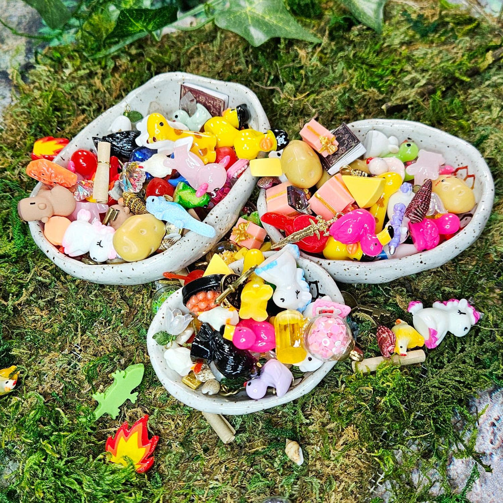 many, many miniature surprise treasures for squirklees. there are mini animals, foods, shells, etc... all piled up in bowls