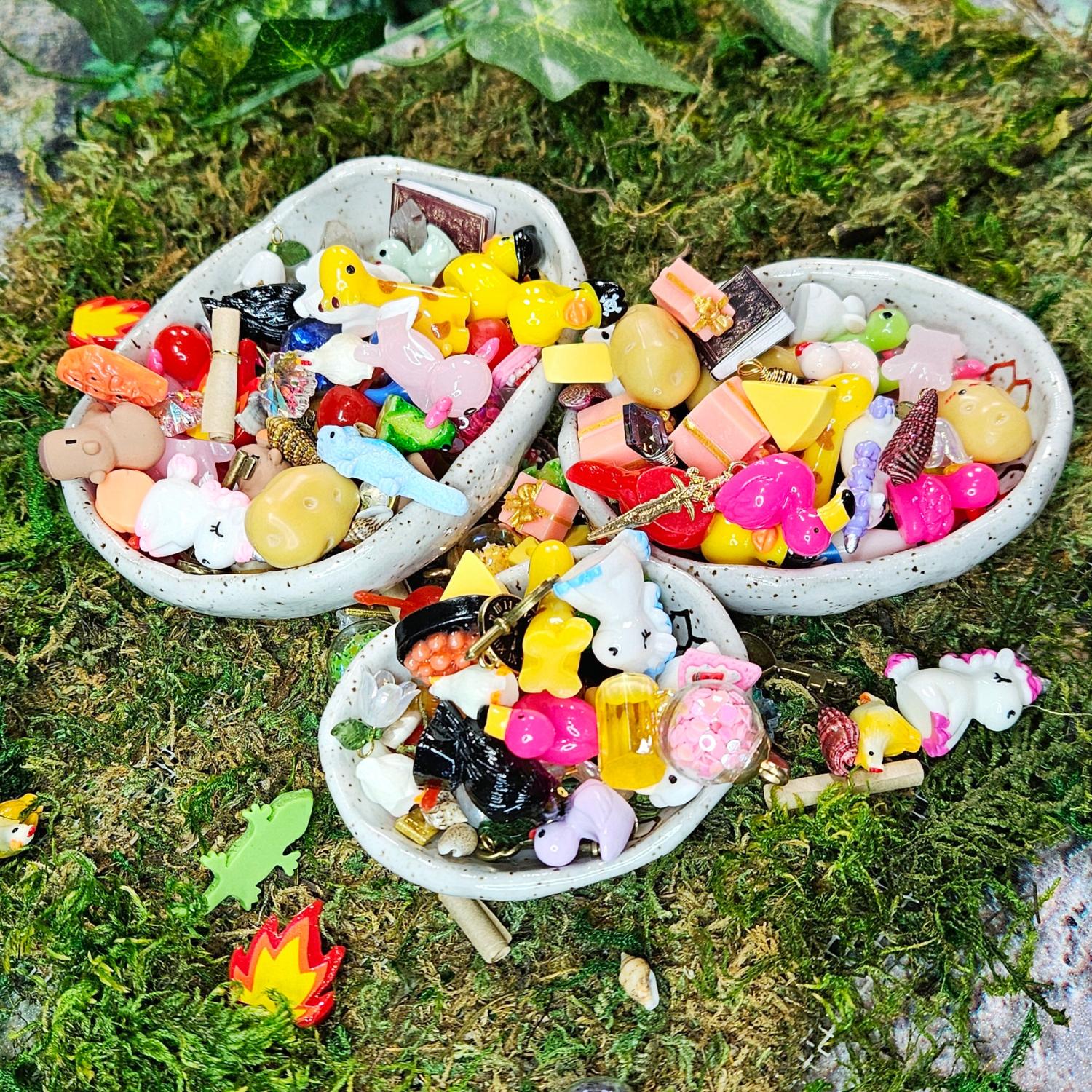 many, many miniature surprise treasures for squirklees. there are mini animals, foods, shells, etc... all piled up in bowls