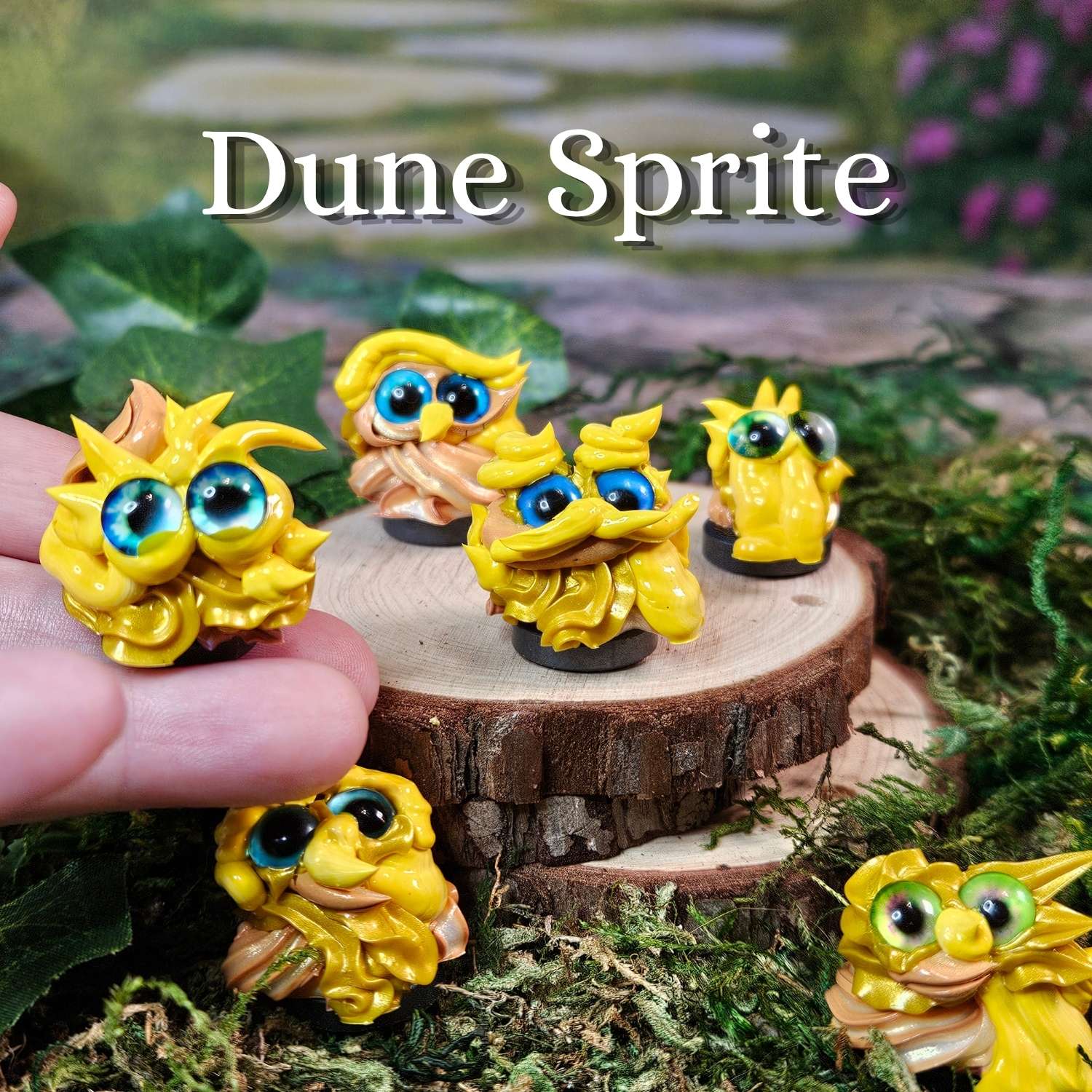 Five small yellow fantasy frosting creature figurines with large blue eyes are displayed on a wood slice and moss, with one held in a hand. The text 'Dune Sprite' appears at the top.