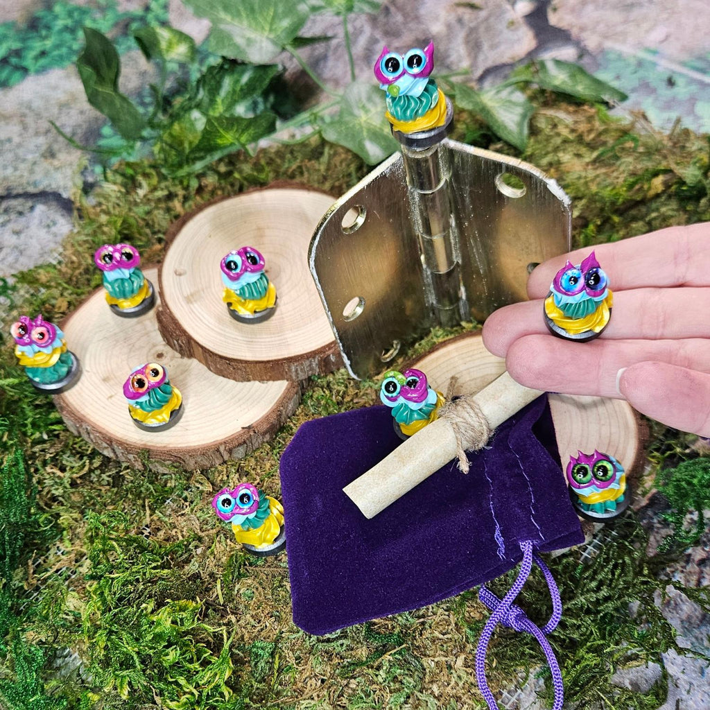 super tiny frosting style creatures on magnets that sit atop door hinges to carry intentions or blessings, posed with a hand, velvet bag and scroll