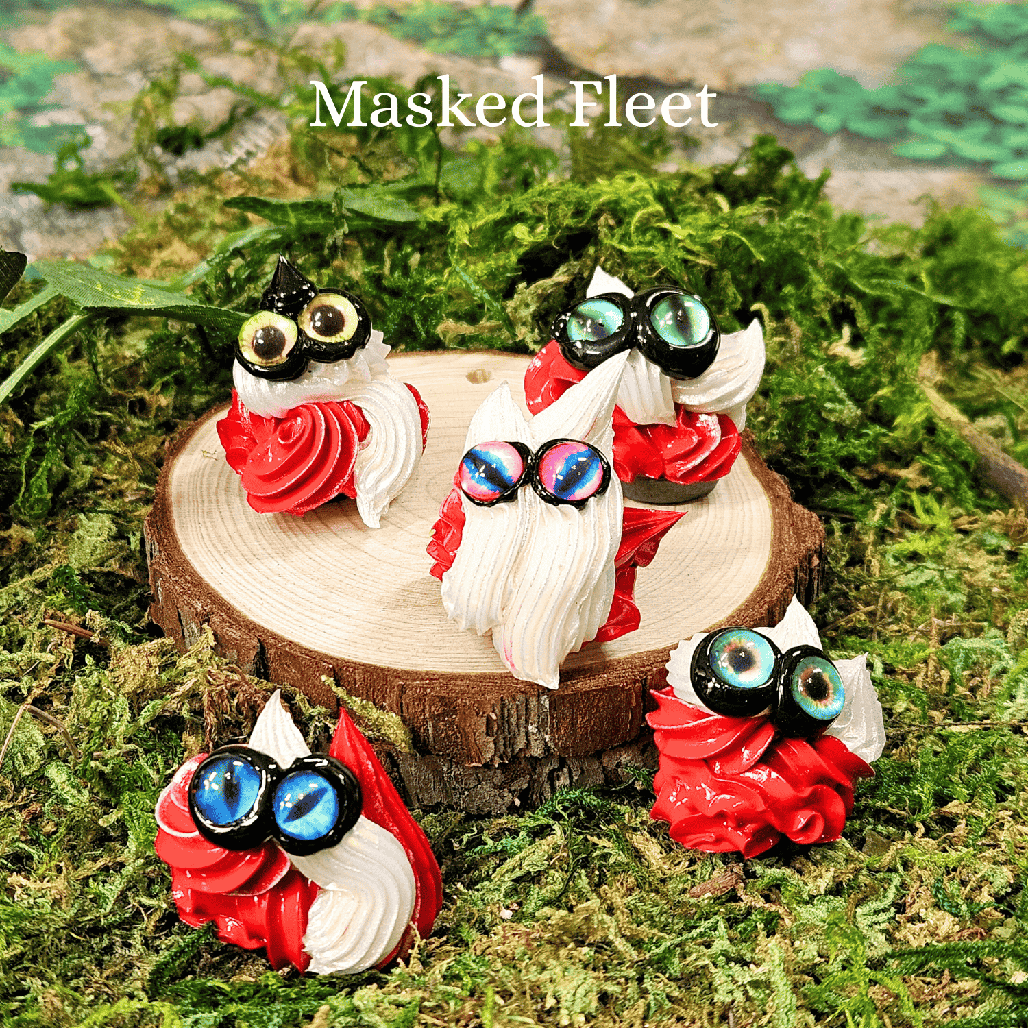 Small frosting creatures with colorful eyes on a wooden stump surrounded by green foliage with the text "Masked Fleet"