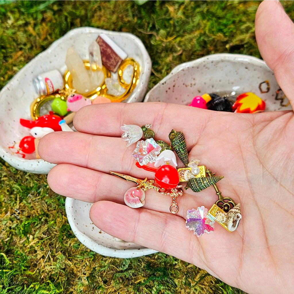 mini cherry, miniature shells, daggers, snowflakes, flowers and booty in a hand - treasures for squirklees to guard