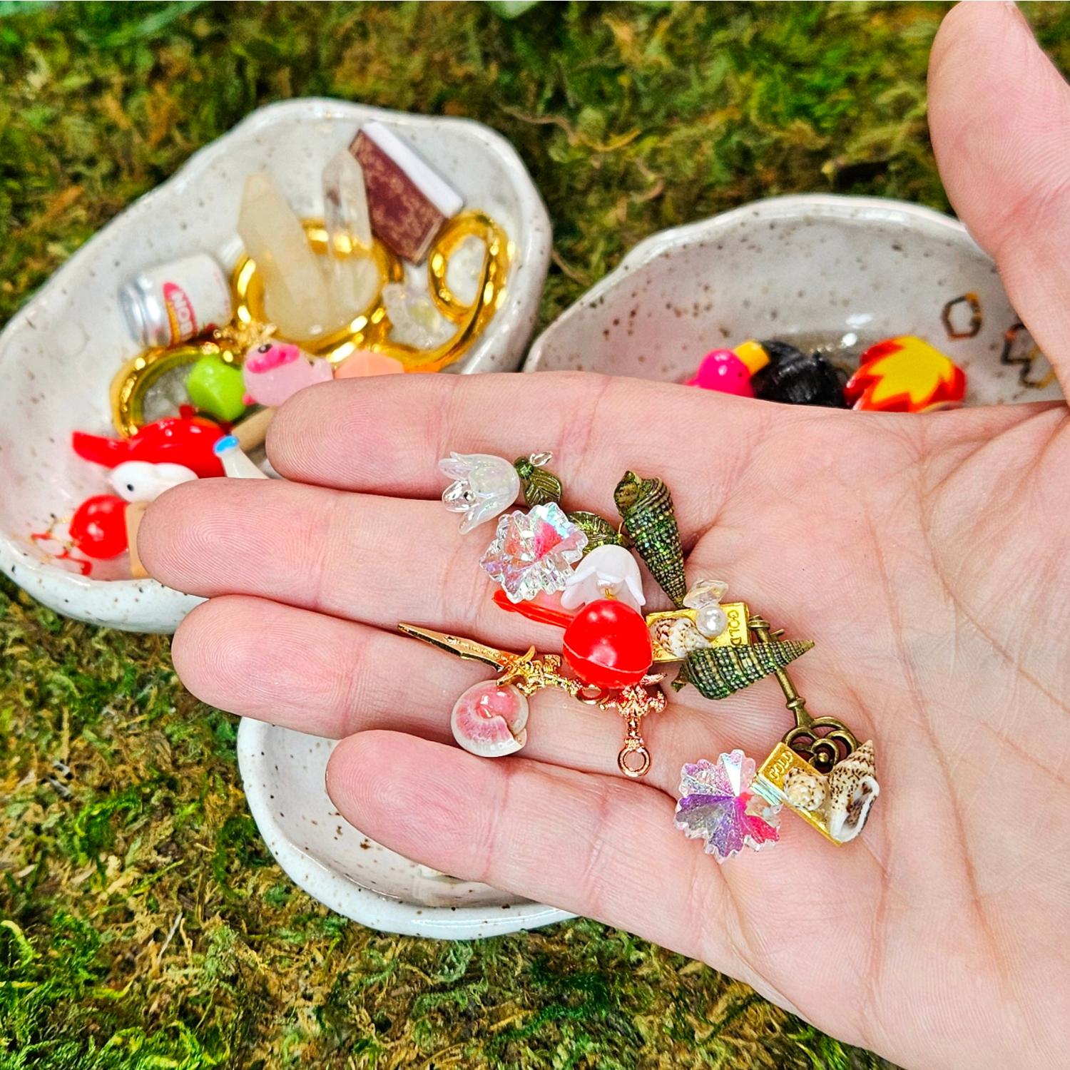 mini cherry, miniature shells, daggers, snowflakes, flowers and booty in a hand - treasures for squirklees to guard