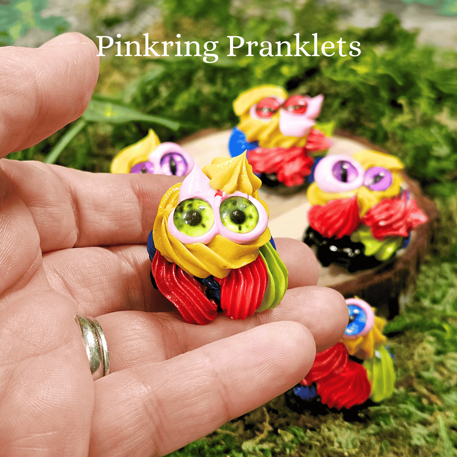 Colorful frosting creatures held in a hand with 'Pinkring Pranklets' text above.