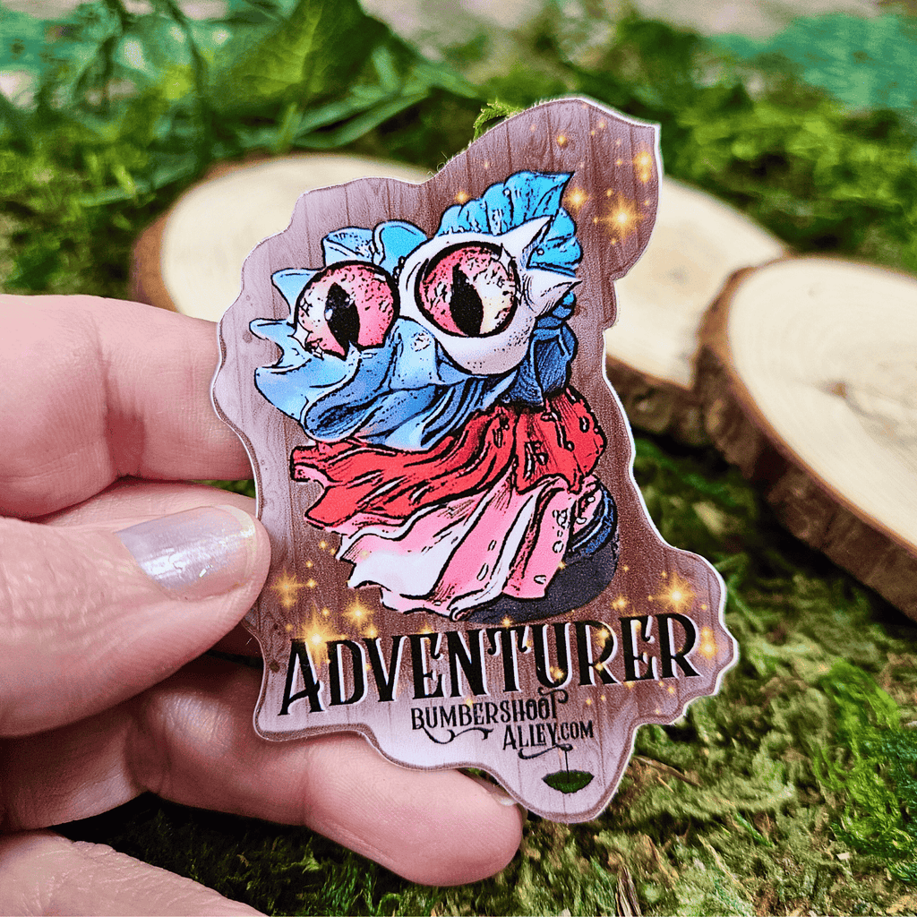 Colorful 'Adventurer' sticker held by a hand on a natural background