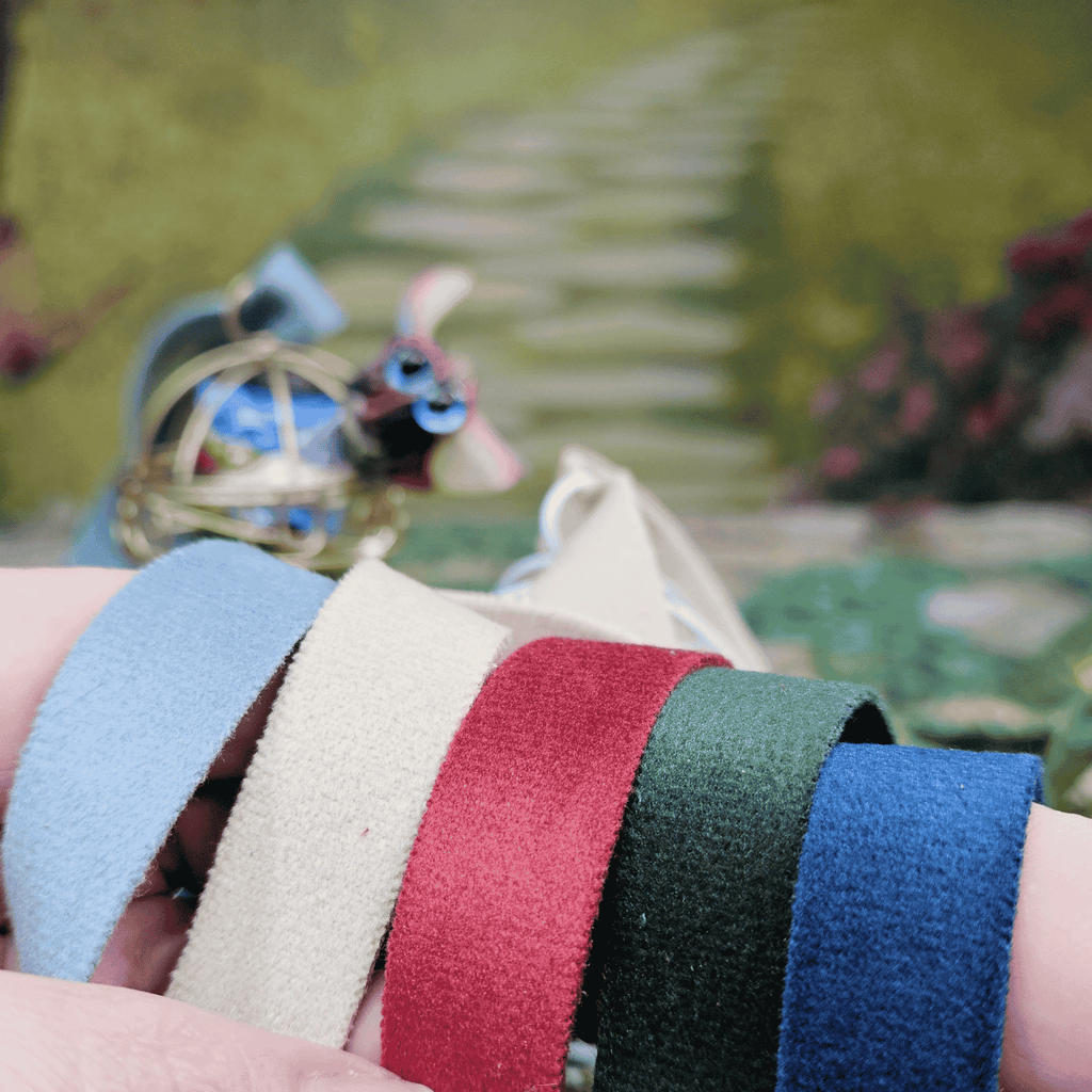 Close-up of colorful fabric strips held by a person with a blurred natural background