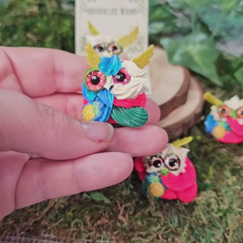 tiny frosting creatures called squirklees with hot pink, blue & green frosting and yellow wings