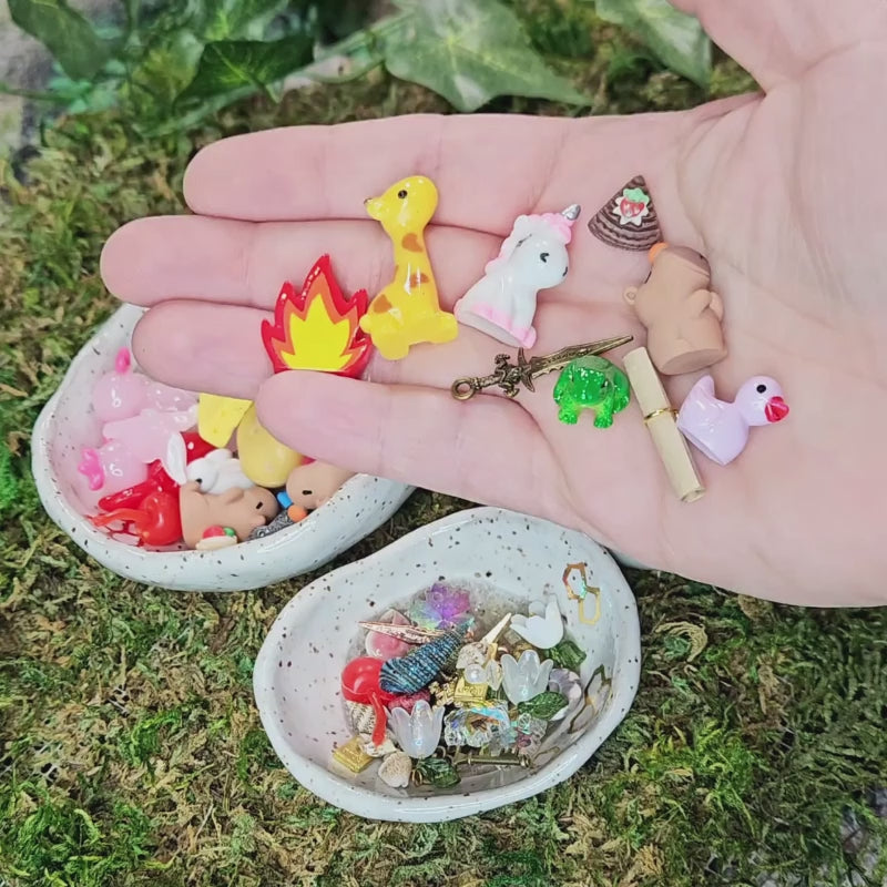many many tiny treasures of various miniatures of animals, books, foods, etc, being poured into dishes